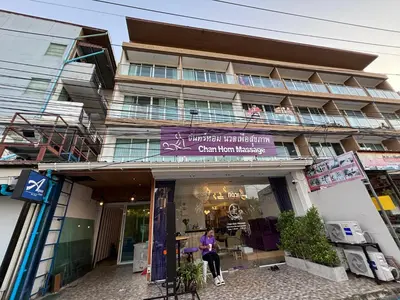 a woman sitting in front of a building at Aqua Inn Ao Nang in Ao Nang Beach