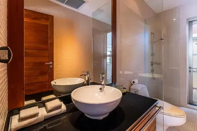 a bathroom with a sink and a toilet and a mirror at Exotic 3BR Villa Solandra with Tropical Pool and Private Rooftop Terrace in Bangtao in Bang Tao Beach
