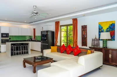 a living room with a white couch and red pillows at Exotic 3BR Villa Solandra with Tropical Pool and Private Rooftop Terrace in Bangtao in Bang Tao Beach