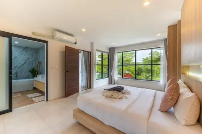 a bedroom with a large white bed with windows at V212 One Of The Most Beautiful Villa In Phuket in Bang Tao Beach