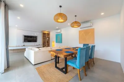 a dining room with a table and a couch at V212 One Of The Most Beautiful Villa In Phuket in Bang Tao Beach