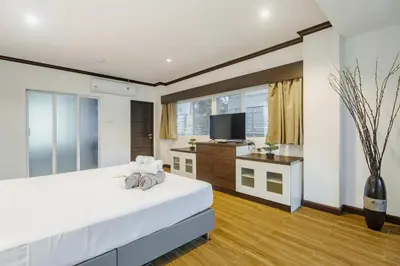 a bedroom with a large white bed and a television at Karon View 2 Bed 5 Minutes walk to Karon Beach 13 in Karon Beach