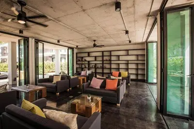 a living room with couches and tables and windows at Room in Rawai in Rawai Beach