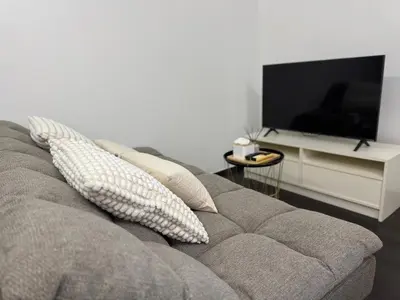 a living room with a couch and a television at Room in Rawai in Rawai Beach