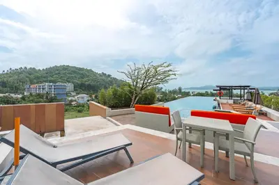 a balcony with a table and chairs and a boat at C209 Surin Beachside Sun Escape & Infinity Pool in Surin Beach