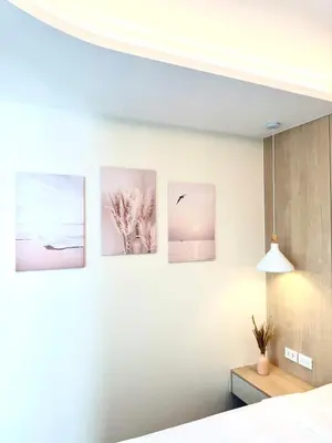 a bedroom with four paintings on the wall at Brand new apartment on Kamala in Kamala Beach
