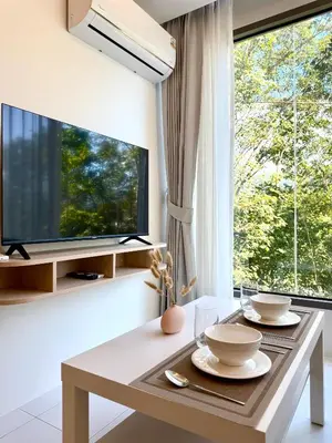 a living room with a table and a large window at Brand new apartment on Kamala in Kamala Beach