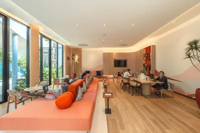 a lobby with people sitting at tables in a building at C213 Fit Chill Condo with Pool and Gym in Kathu