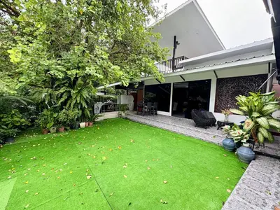 a yard with green grass in front of a house at Rawai House 16 in Ban Saiyuan (1)