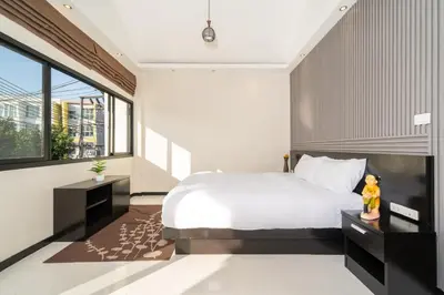 a bedroom with a white bed and a large window at Laguna Townhouse with private pool, Bang Tao Beach in Laguna Phuket