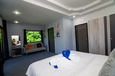 a bedroom with a white bed with a blue bow on it at 3 Bed 3 Bath Villa 400m to Beach in Surin Beach