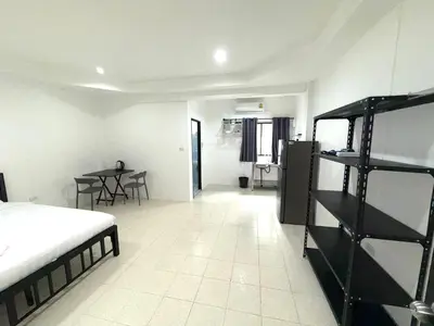 a bedroom with a bed and a table in it at Patong Canal Villa 104 in Patong Beach