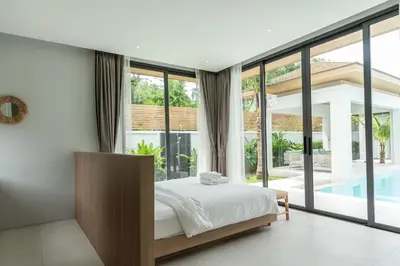 a bedroom with a bed and a large window at Mouana Breeze Mai Khao 4-bedroom Pool Villa 9919 in Mai Khao Beach