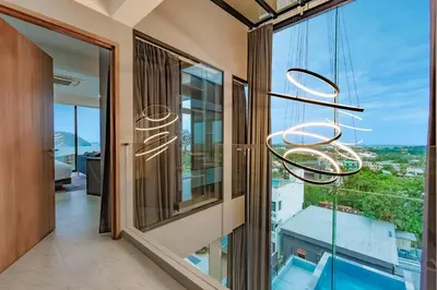 a chandelier hangs from a window in a house at Luxury 6BR Seaview Statement Villa - Villa Legend in Ban Saiyuan (1)