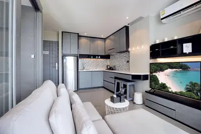a living room with a white couch and a tv at Scenic Hill View Apartment CTG P609 in Tropics Kamala residence, Great Facilities, Close to Beach and Fantasea in Kamala Beach