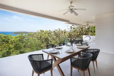 a dining room with a table and chairs and the ocean at Stunning Seaview Escape - Modern and Elegant in Kata Beach