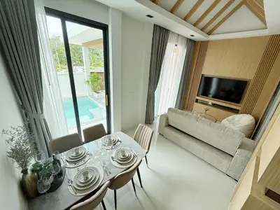 a living room with a table and a couch at Relax Nai Yang beach pool Villas in Nai Yang Beach