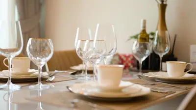 a table with wine glasses and plates and a bottle of wine at Relax Nai Yang beach pool Villas in Nai Yang Beach