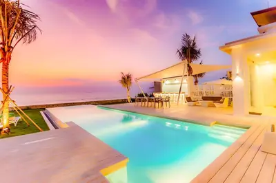 a house with a swimming pool next to the ocean at Baan Kloi II in Ban Na Tai