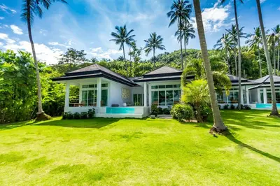 a house with palm trees in front of it at Baan Klong in Ko Yao Noi