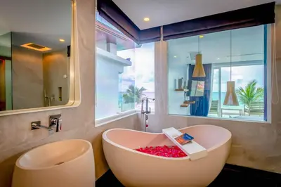 a bathroom with a bath tub with a large window at Baan Kloi III in Ban Na Tai