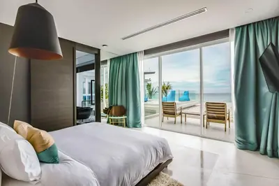 a bedroom with a bed and a view of the ocean at Baan Kloi IV in Ban Na Tai