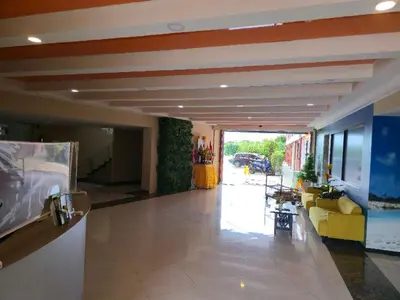 a living room with a lobby with yellow couches at 777 Beach Condotel in Mai Khao Beach