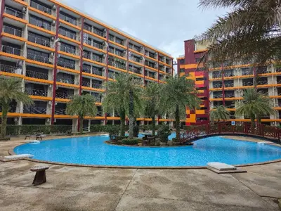 a swimming pool in front of a large building at 777 Beach Condotel in Mai Khao Beach