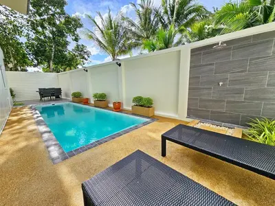 a swimming pool in a backyard with a table and a bench at 2 Bedroom Pool Villa Green View in Kamala Beach