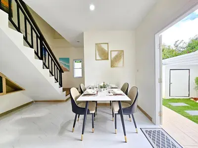 a dining room with a white table and chairs at 2 Bedroom Pool Villa Green View in Kamala Beach