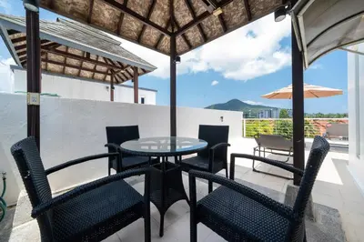 a patio with a table and chairs and an umbrella at Sunny Paradise Kamala Beach in Kamala Beach