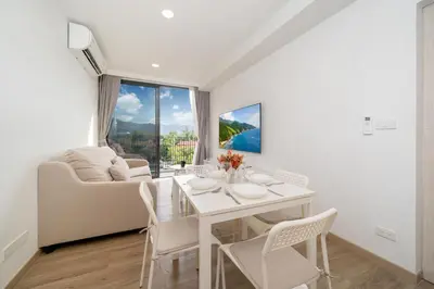 a white dining room with a white table and chairs at Skypark Laguna Bang Tao Beach in Laguna Phuket