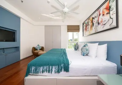 a bedroom with a white bed and a ceiling fan at JSD Prime Property-Surin Beach in Surin Beach