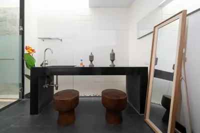 a bathroom with a counter with a sink and two stools at Wings Villa Laguna Bang Tao Beach Phuket in Ban Pak Lak