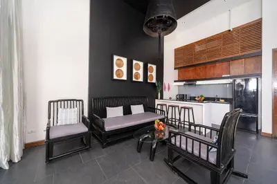 a living room with two chairs and a kitchen at Wings Villa Laguna Bang Tao Beach Phuket in Ban Pak Lak