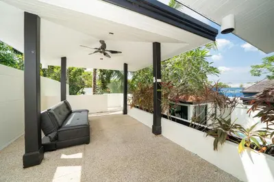 an outdoor patio with a couch and a ceiling fan at Wings Villa Laguna Bang Tao Beach Phuket in Ban Pak Lak