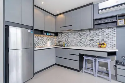 a kitchen with a stainless steel refrigerator and gray cabinets at Tropics Kamala Hill View Apartment CTG D704 near Beach and Fantasea in Kamala Beach