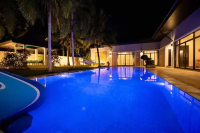 a swimming pool at night with blue lights at Bua Sawan - 4 Bedrooms Pool Villa in Ban Pak Lak