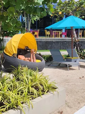 a woman laying in a tire in a park at Cassia Loft Laguna Phuket Bang Tao Beach in Laguna Phuket