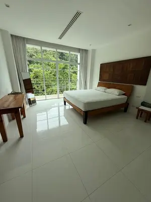 a bedroom with a bed and a large window at Grand kamala falls in Kamala Beach
