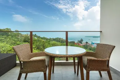 a glass table and two chairs on a balcony at Prime Location Kamala Ocean View Suite OCN C64 just 450m to the Beach in Kamala Beach