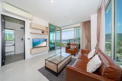 a living room with a leather couch and a television at Kamala Ocean View 2BR Apartment OCN C35, just 5 min walk to the Beach in Kamala Beach