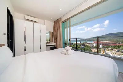 a bedroom with a large white bed and a large window at Kamala Ocean View 2BR Apartment OCN C35, just 5 min walk to the Beach in Kamala Beach
