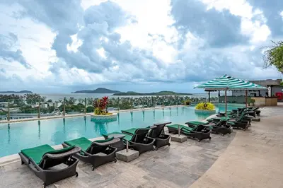 a large swimming pool with chairs and an umbrella at C214 Condo Seaview Pools Gym Walk to Rawai Beach in Rawai Beach