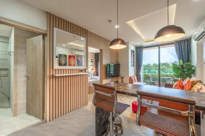 a kitchen with a bar with a bench and a bathroom at C214 Condo Seaview Pools Gym Walk to Rawai Beach in Rawai Beach