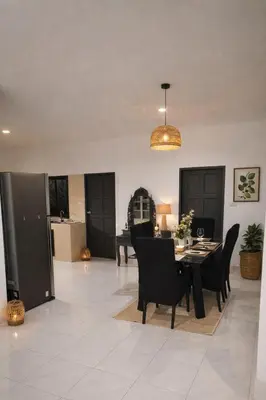 a dining room and living room with a table and chairs at Villa Lilly in Rawai Beach