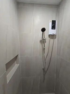 a shower with a soap dispenser in a bathroom at Hommory Residence - Phuket Town in Ban Lo Long