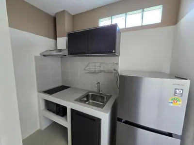 a small kitchen with a sink and a refrigerator at Hommory Residence - Phuket Town in Ban Lo Long