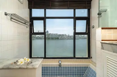 a bathroom with a window and a tub with a view of the water at Allamanda Townhouse Laguna Phuket Bang Tao Beach in Laguna Phuket