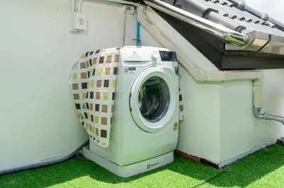 a washing machine sitting in the side of a house at Allamanda Townhouse Laguna Phuket Bang Tao Beach in Laguna Phuket